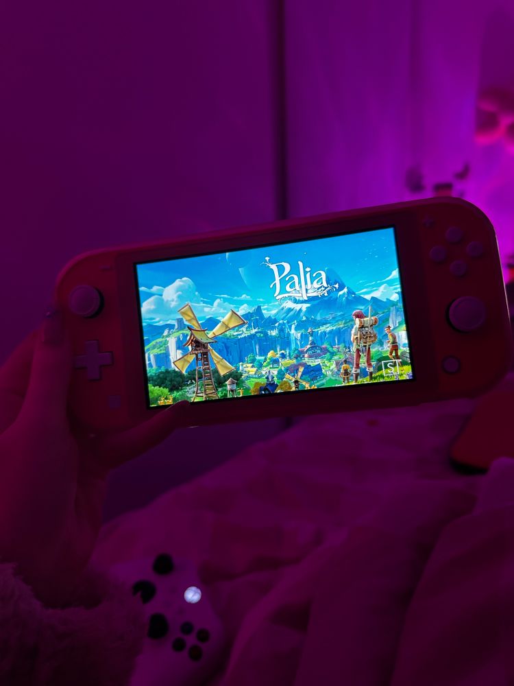 Nintendo switch with Palia game load screen in pink lighting 