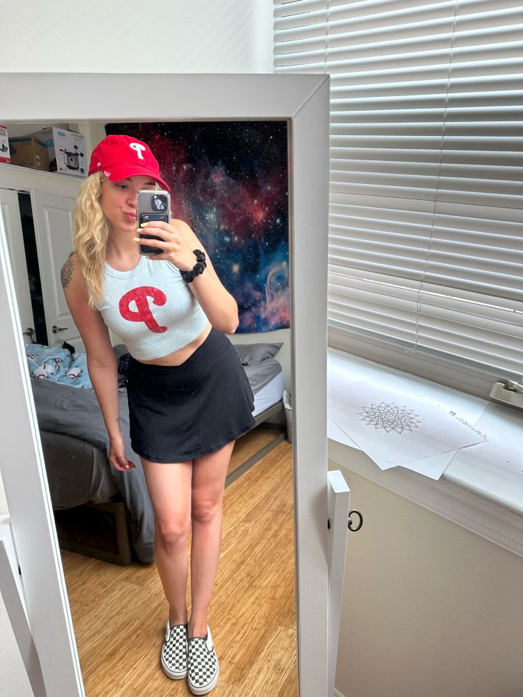 women in phillies hat and shirt with black skirt 