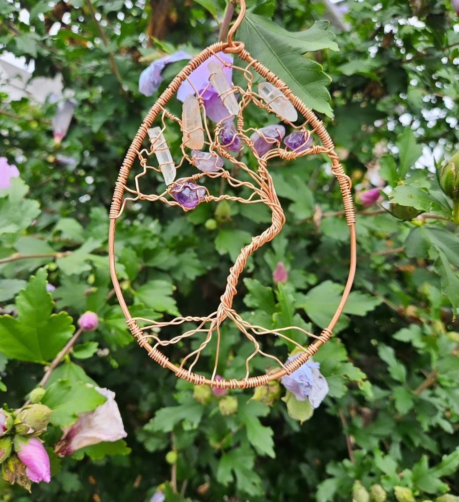 Sun catcher in front of leaves and flowers