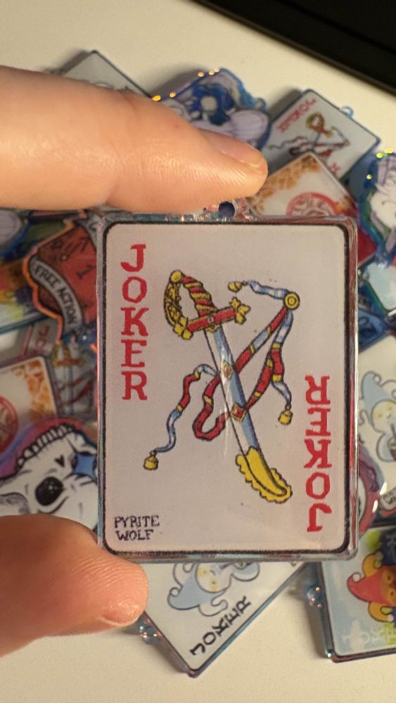 acrylic keychain of a balatro joker inspired by the spanish card of the ace of swords