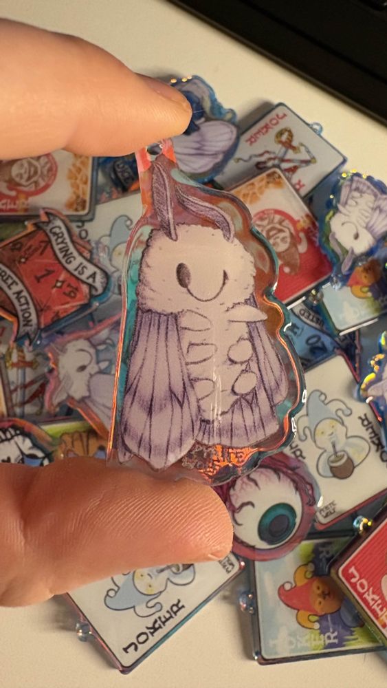 acrylic keychain of a sleepy moth