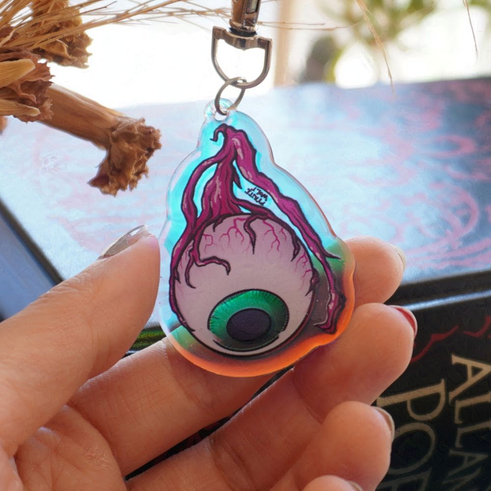 acrylic keychain of an eyeball with a holographic gleam