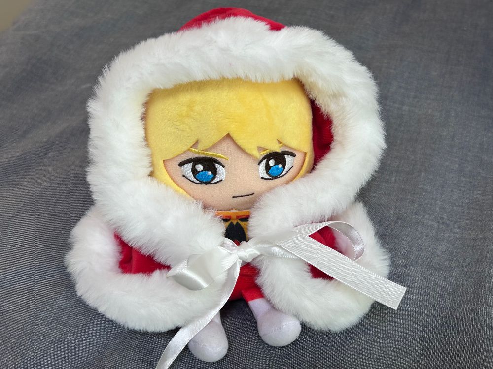 ふわふわポンチョを着ているシャアのぬいぐるみ 赤地に白のふわふわがついている