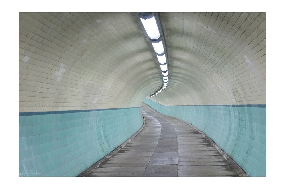 turquoise and cream Victorian style tiling in a tunnel heading off into the distance 