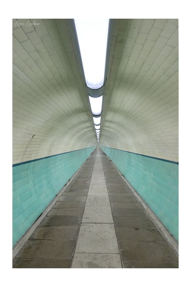 turquoise and cream Victorian style tiling in a tunnel heading off into the distance 