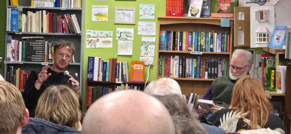 Dan hicks talking to a room of people in a bookshop