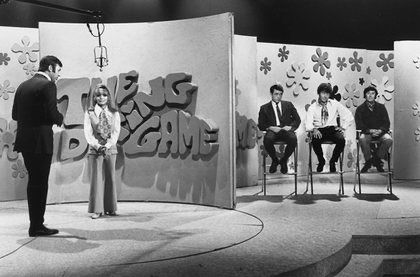 Black and white photo of the dating game show veiwed from the audience left side of the set. 