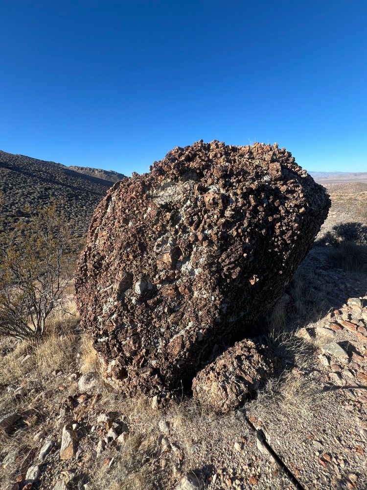 A large brown boulder full of angular pieces. 
