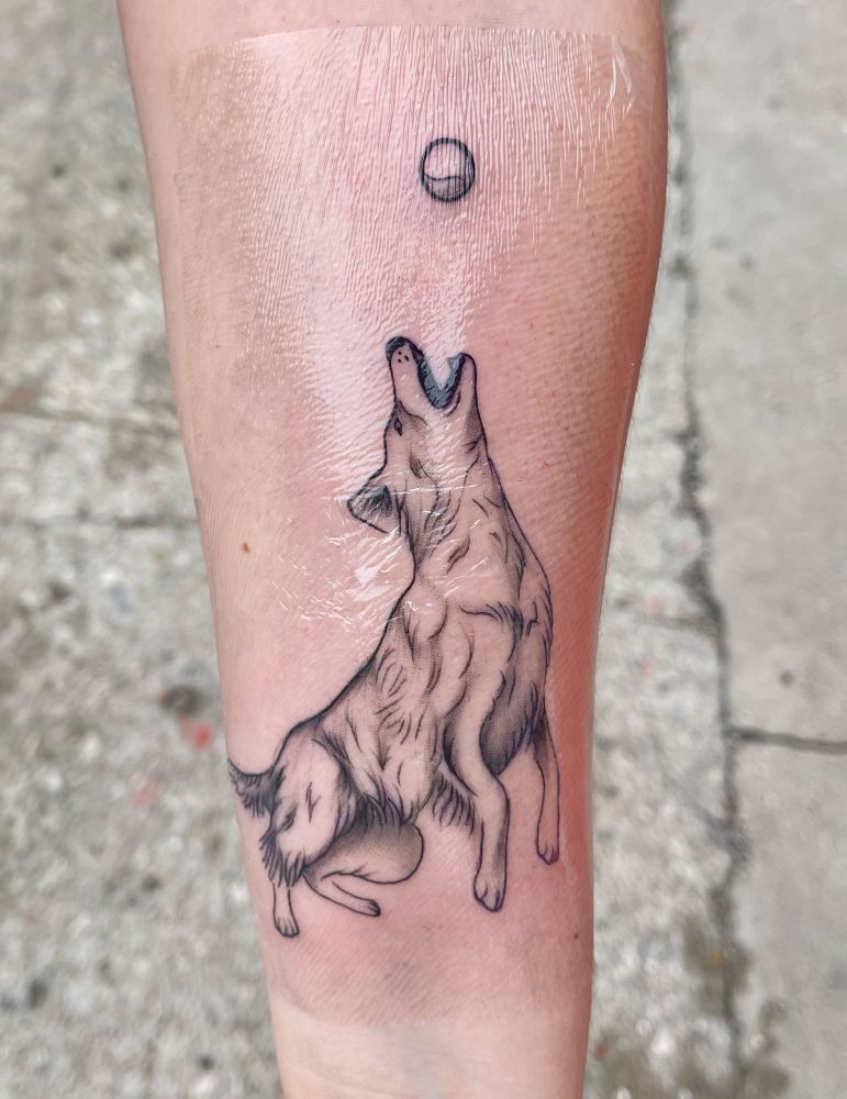 Forearm tattoo of the previously pictured border collie jumping to catch a ball