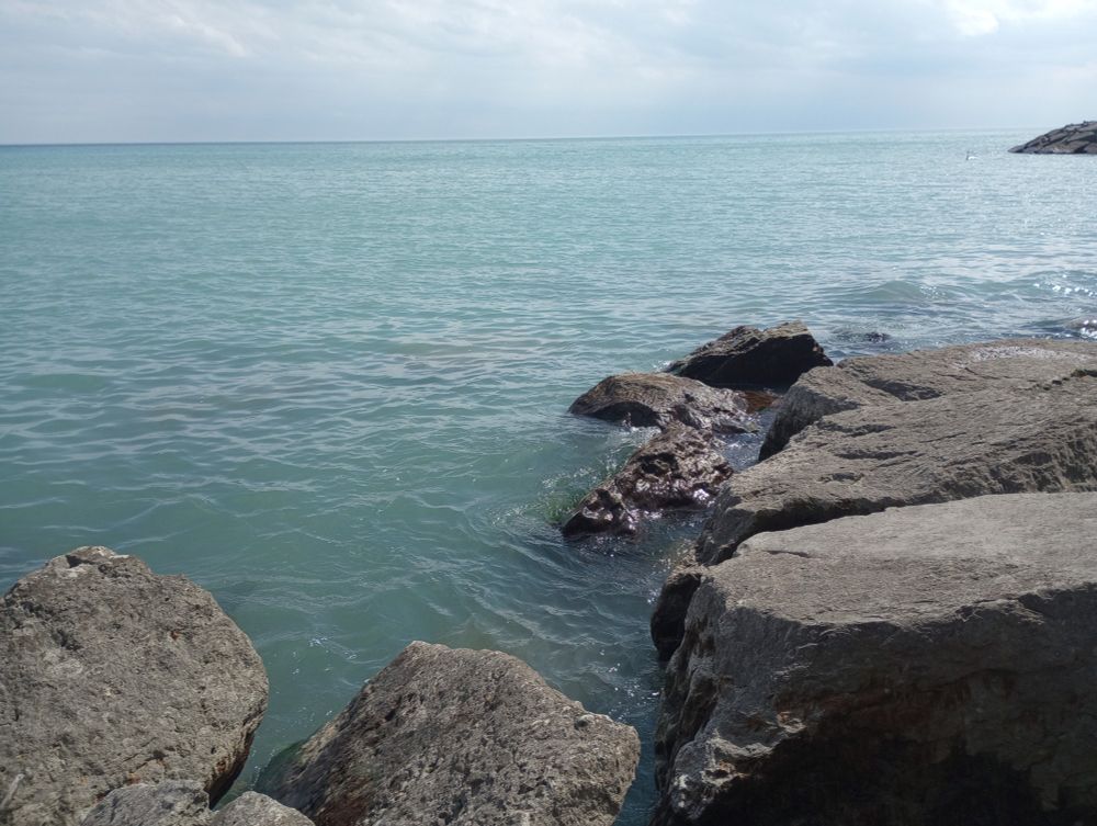 A photo of rocks by the lake during the daytime.