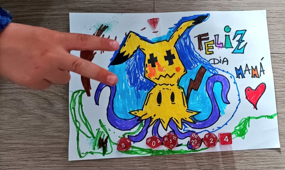 Dibujo del Pokémon Mimikyu realizado por un niño como regalo del Día de la Madre a su mama.

Tiene una fila de dados en la parte inferior que indican, con sus caras, el día 5 de mayo de 2024.