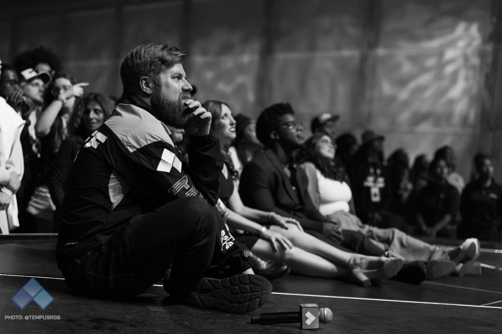 Rick, GM of Evo, sitting on stage with the hosts as they watch the closing credit roll at Evo 2025.