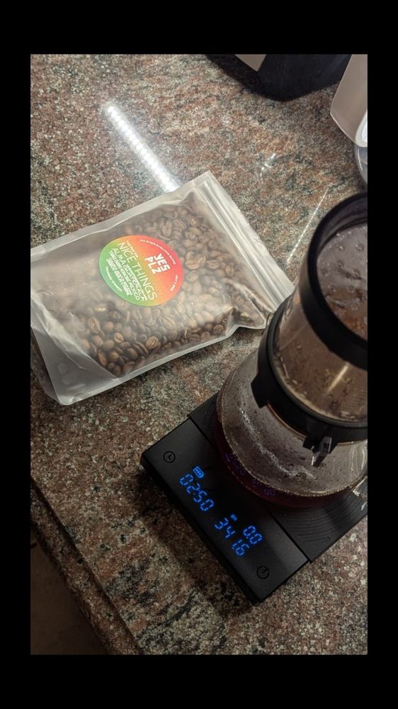 A coffee pour over setup and a bag of coffee beans on a kitchen counter.