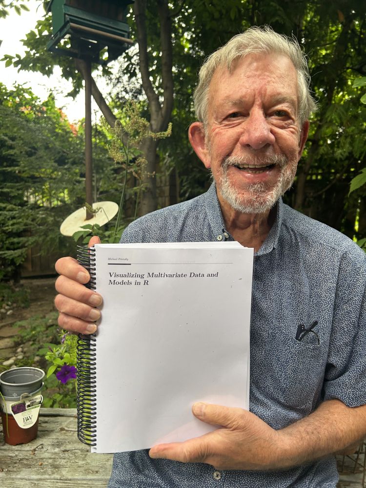 Photo of me holding a printed copy of my book