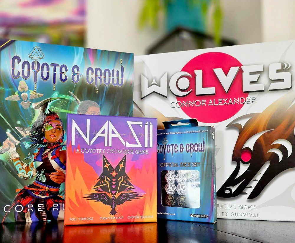 A display of Coyote & Crow Games from Connor Alexander, including Coyote & Crow the roleplaying game, Naasii, Wolves and custom dice for the RPG. 