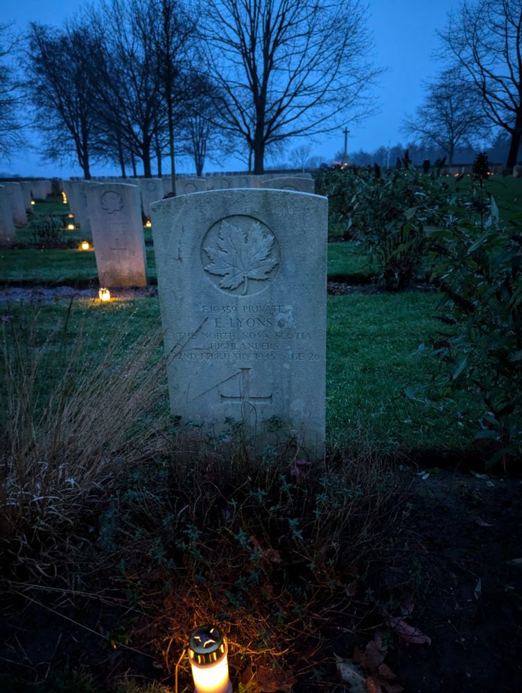 The grave of a Canadian soldier with a lit tombstone