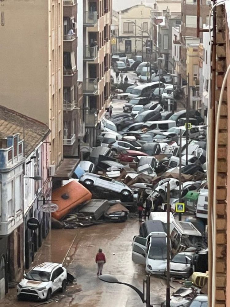 A Valencia street filled with crumpled and piled cars left behind after the record-breaking flooding.