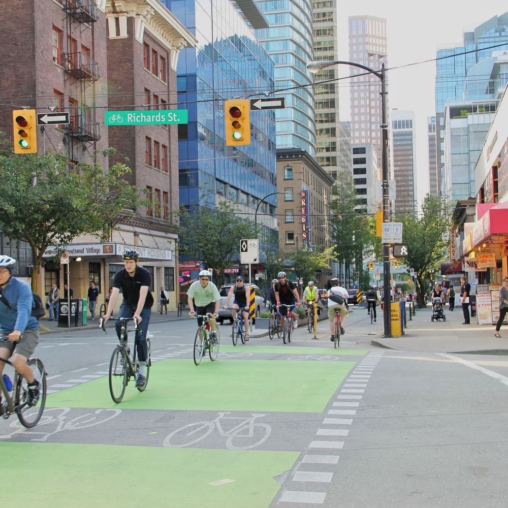 People riding in a safe bike-lane in downtown Vancouver