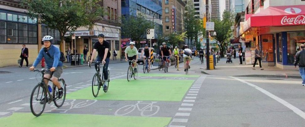 People riding bikes in a protected bike lane in downtown Vancouver