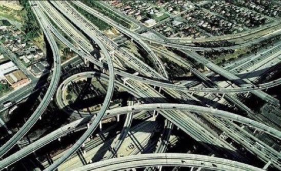 Images of freeways with many lanes filled with car traffic that will never be solved by adding more lanes