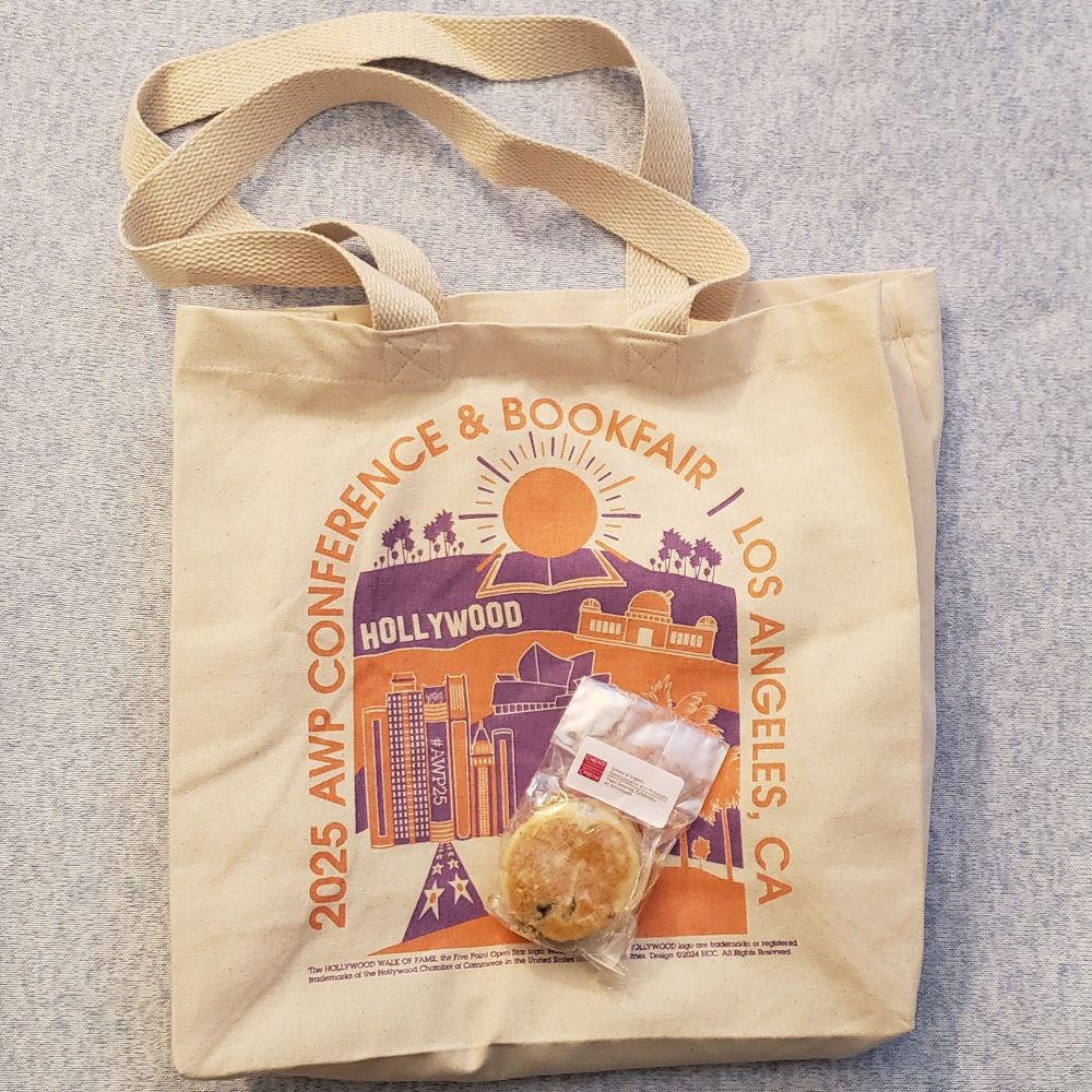 Photo of my AWP Conference & Bookfair bookbag with a welshcake perched on top.