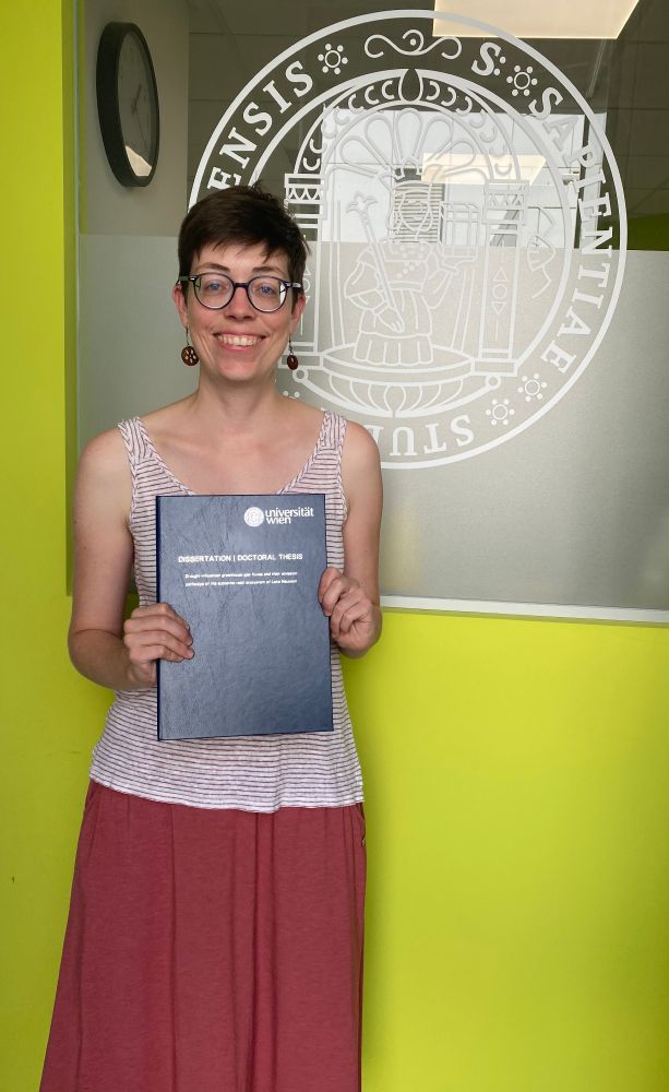 Pamela in front of the Geoecology Laboratory at the University of Vienna with a printed copy of her doctoral thesis!