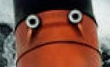 A close up of the steam stack on the boat. It looks like a sad orange-red face with two beady eyes and a black hat. 