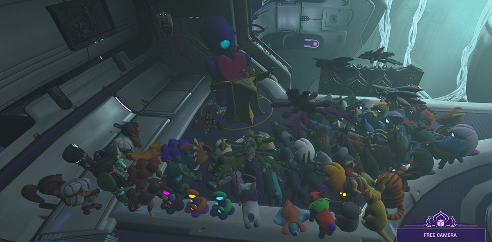 The Council of Floof. There are way too many plushies at this corner of my ship in Warframe, I will not cite every single one.

They gather around a bigger plushie, that seems half the size of a person, in a podium, holding a big heart because she loves you <3