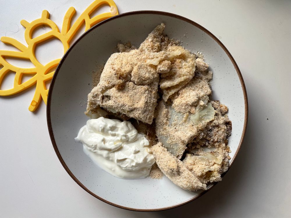 A chunk of the cabbage dish plated up, the mushroom, onion and chestnut filling now visible. There’s a hearty dollop of sour cream on the side. 