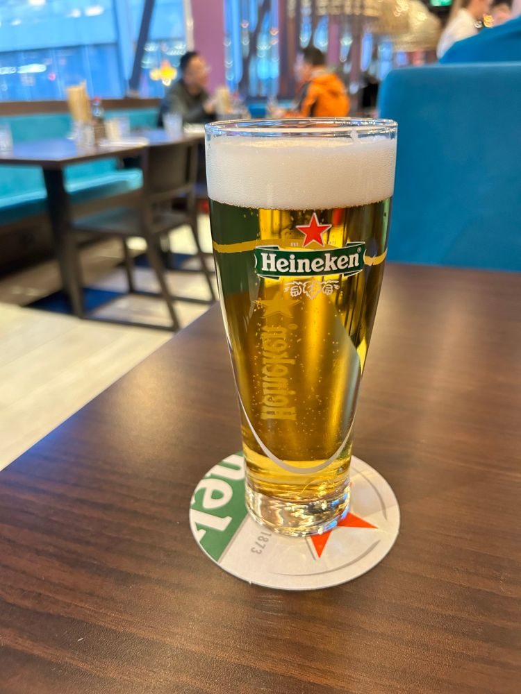 A medium glass of Heineken on a Heineken beer mat. This alt text is sponsored by Heineken. If you drink Heineken then your Heineken aura will be replenished. 