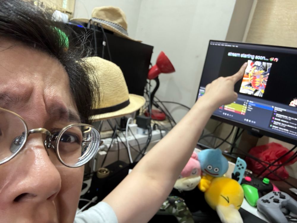 A jacnotjac selfie pointing at her monitor that says “stream starting soon”. 