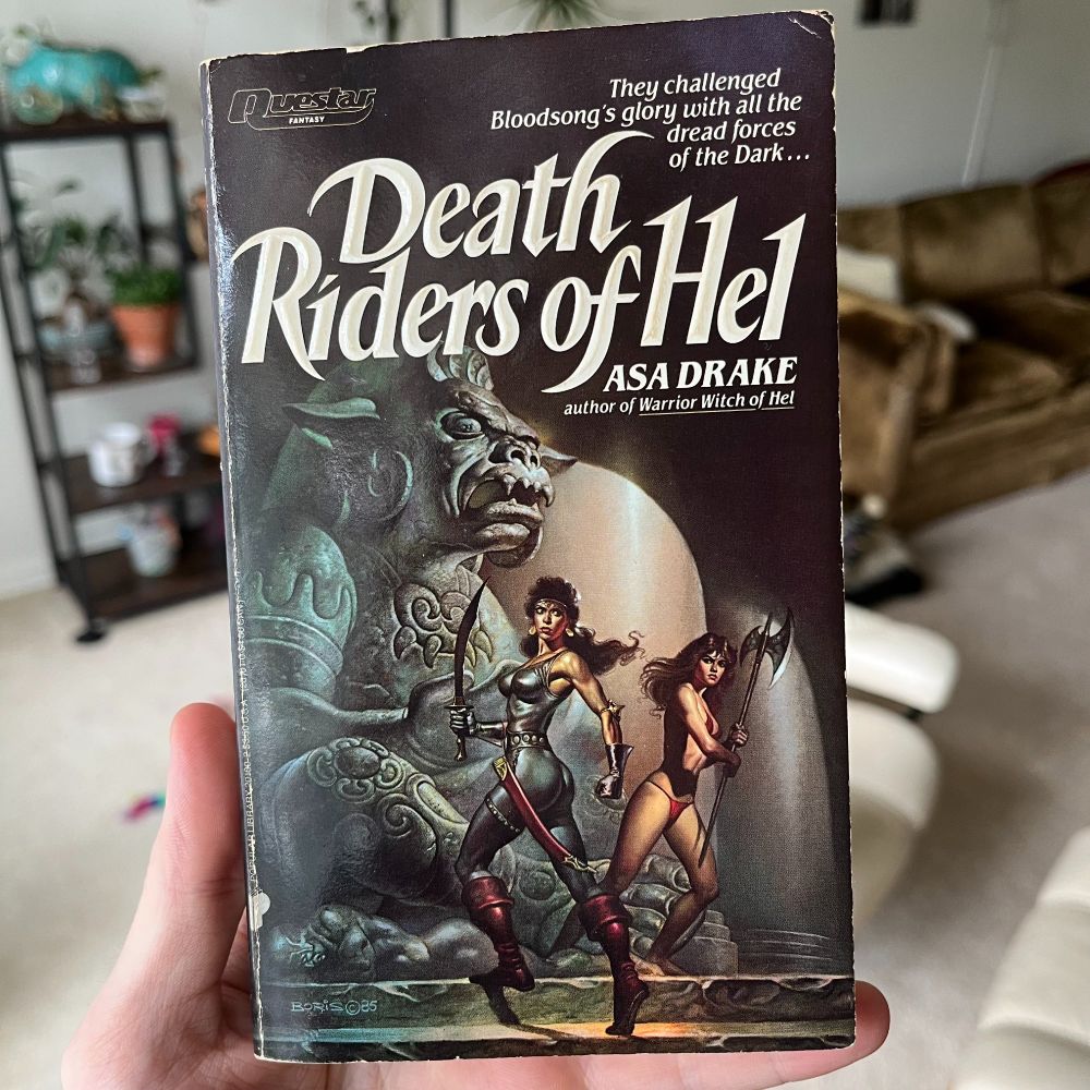 Pulp novel cover: Death Riders of Hel by Asa Drake, featuring two lean warriors ready to battle before a large devilish statue.