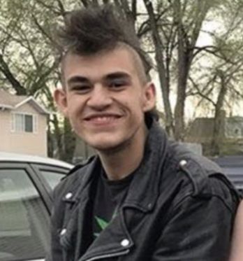 A young Latino punk with a goofy smile and a mohawk, wearing a leather jacket