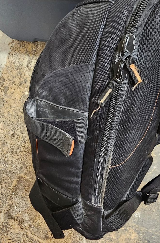 A backpack with a small amount of white powdered pepperball residue on it