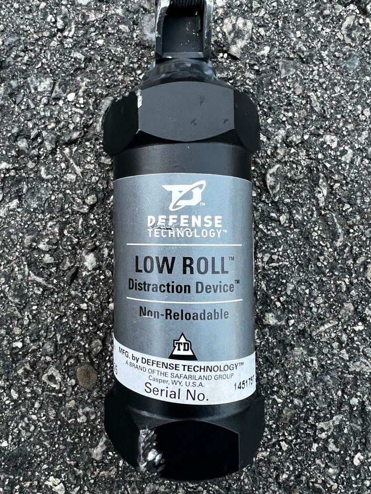 A black canister labeled DEFENSE TECHNOLOGY™
LOW ROLL™
Distraction Device™
Non-Reloadable
MFG. by DEFENSE TECHNOLOGY™