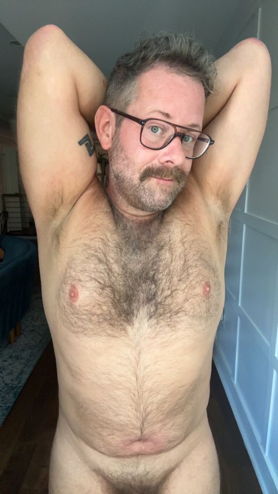 A man (me) stands facing the camera, shirtless, displaying a hairy chest.