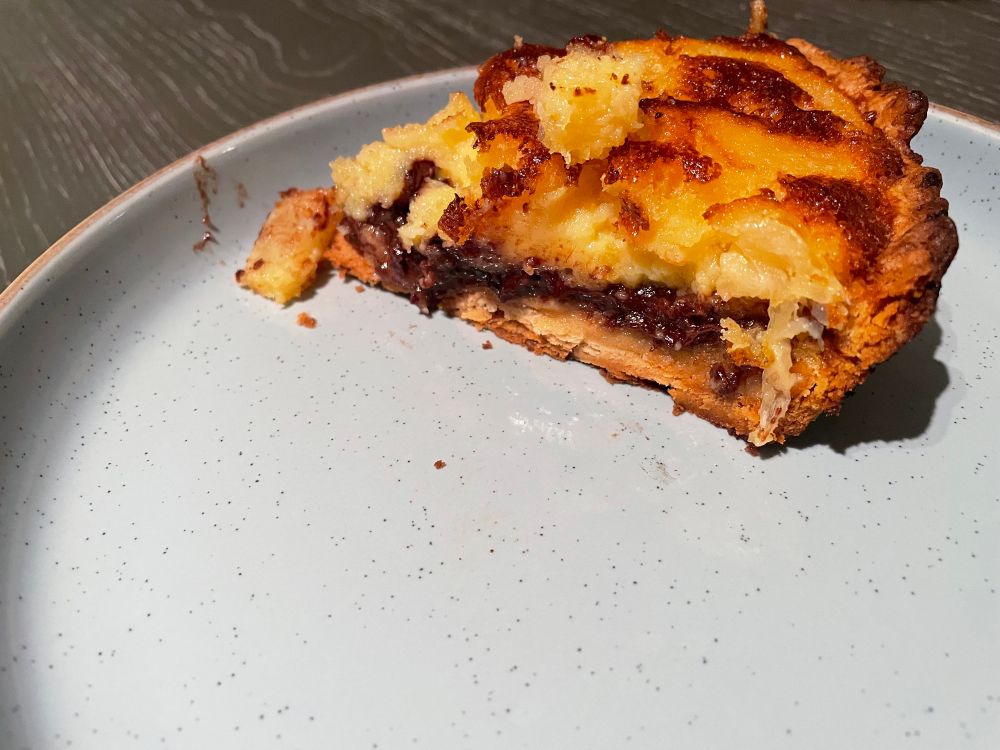 Side view of pineapple chess pie with layer of dark chocolate and marzipan. 