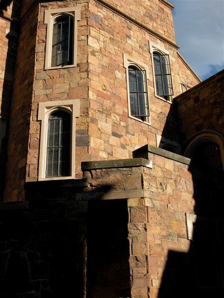 Angular shadows and light with narrow castle windows in limestone casings and sandstone facade 