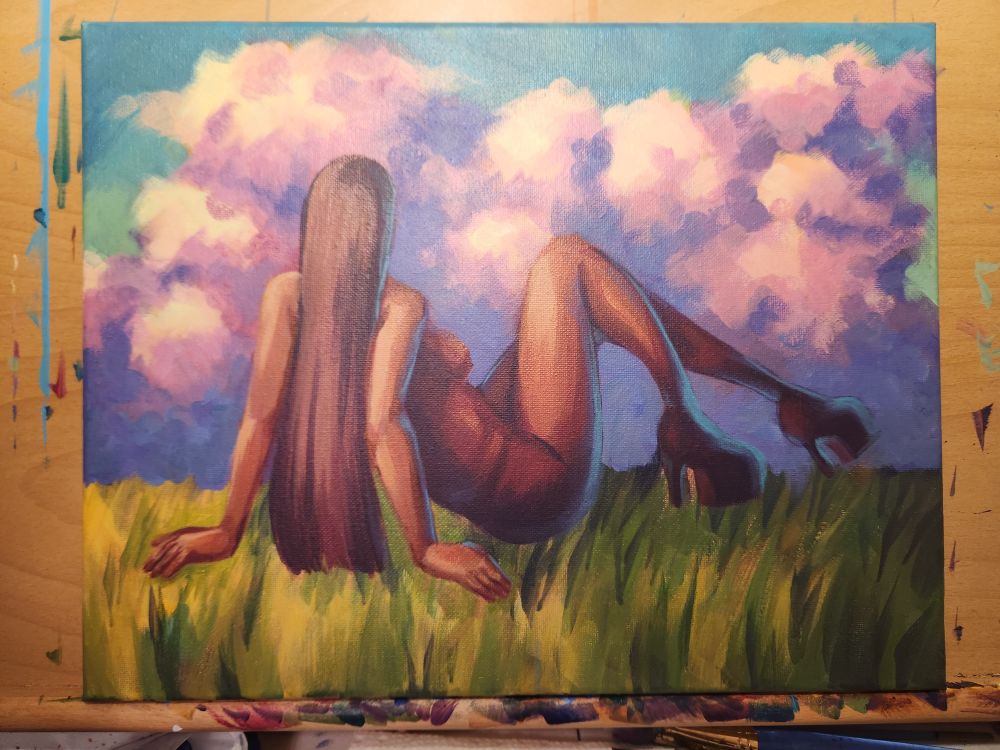 An acrylic work in progress, showing a woman lounging in a field looking at sunset clouds