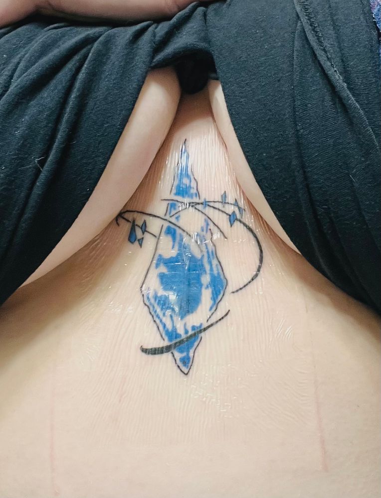 Tattoo of a large blue crystal surrounded by smaller circling crystals