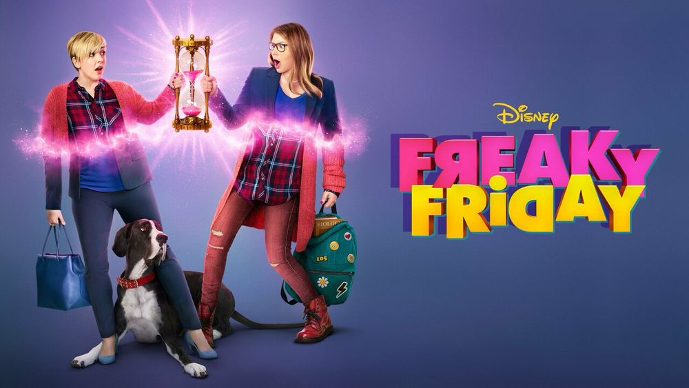 Two actresses stand on opposite sides of each other on a purple background. They are holding a pink hourglass and it appears they are in the process of magically switching bodies. There is a Great Dane dog named Boris sitting between them. The text reads “Freaky Friday” in bright pink and yellow bubble letters and some letters are backwards to show switching around and reflecting. 