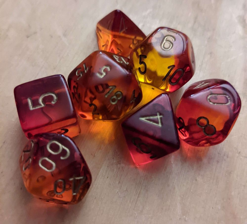 A set of semi transparent red DnD (Dungeon and Dragons) dice lit by natural sunlight on a wood surface.