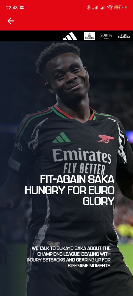 Screenshot of the Arsenal app with Saka wearing the black kit with the headline "Fit Again Saka Hungry for Euro Glory" and subheadline "We talk to Bukayo Saka about the Champions League, dealing with injury setbacks, and gearing up for big game moments." 