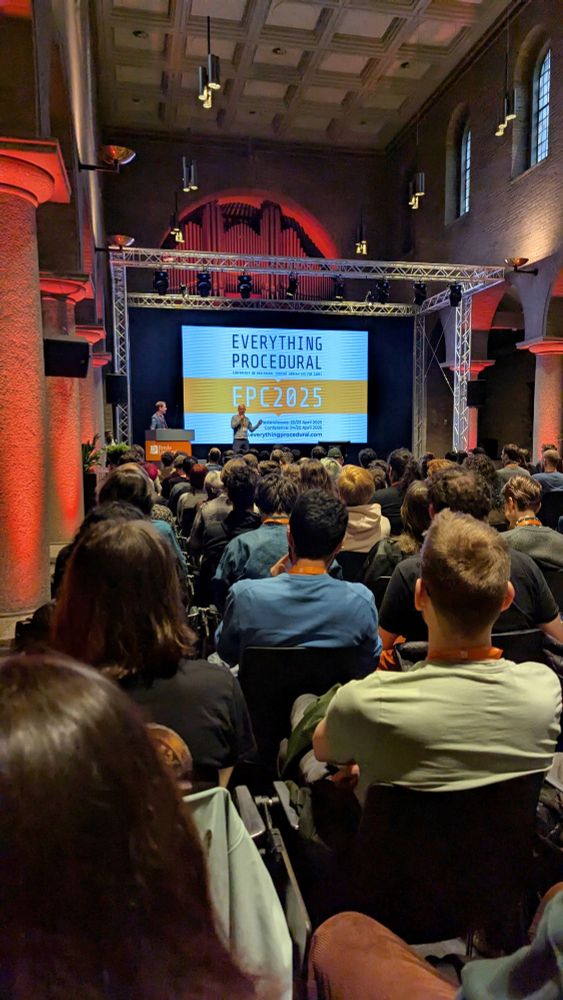 A photo of the crowd and stage at conference Everything Procedural