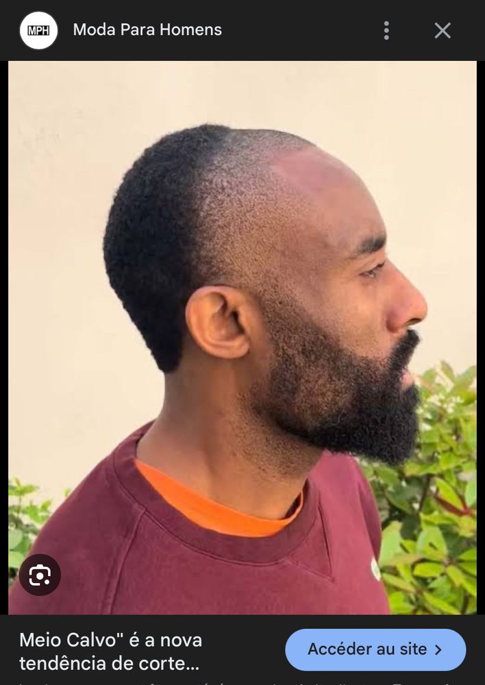 foto de um homem negro com barba e cabelo raspado só na parte da frente (em linha que vai de orelha a orelha), enquanto a parte de trás tem cabelo 