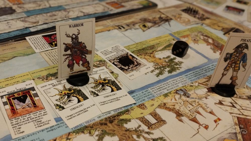 A table covered in a vintage edition version of the classic Games Workshop tabletop game Talisman. Two dragons attack a lone warrior.