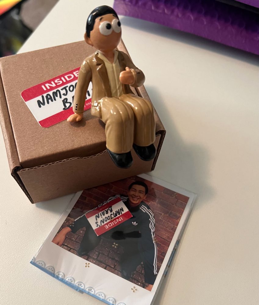 Namjoon figurine sitting on a box with “Namjoon’s brain” stickers from his MV Lost!