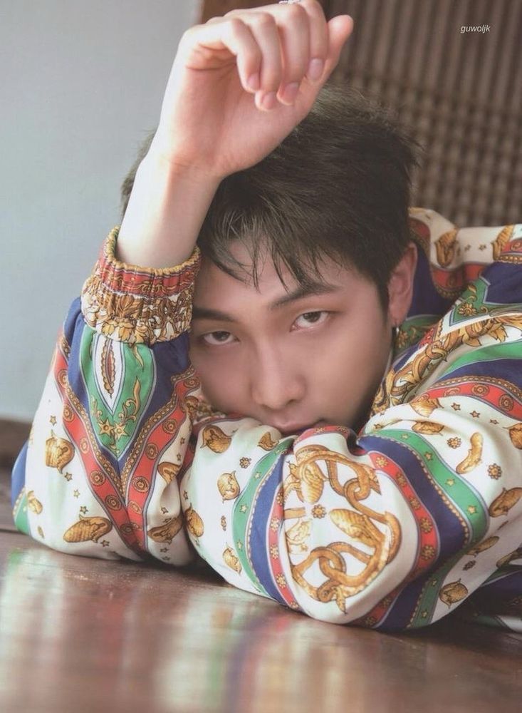Kim Namjoon in colored shirt staring into camera with his dragon eyes.