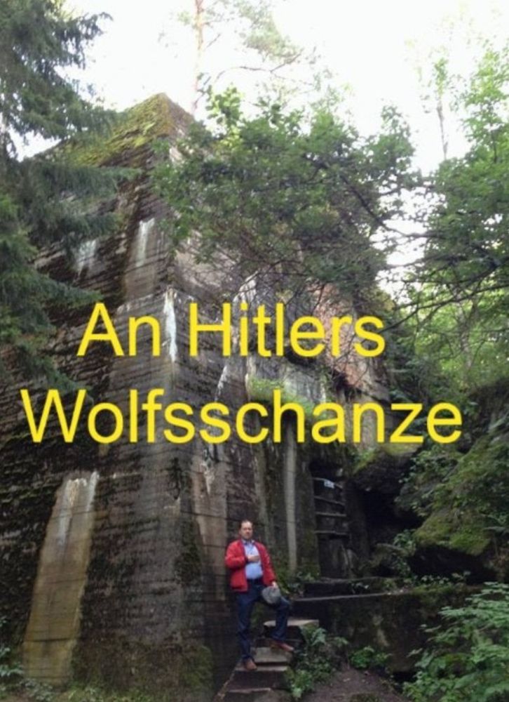 Droese posiert vor Hitlers Wolfsschanze mit Hand auf dem Herz.