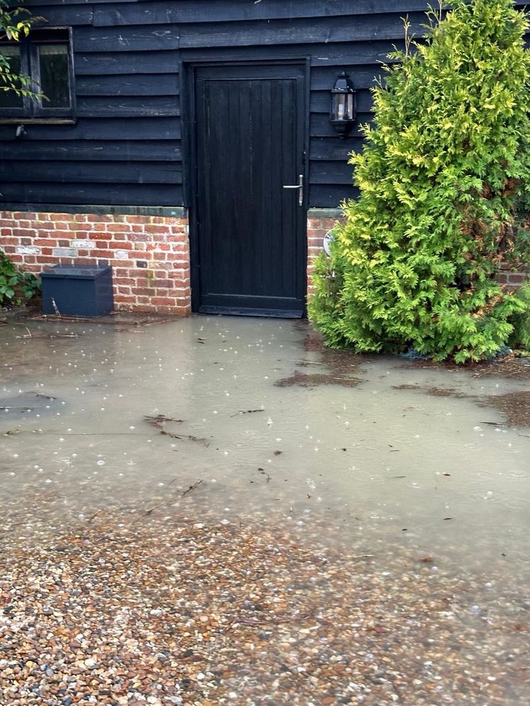 flood water on gravel in front of the door into a wooden barn (our house)